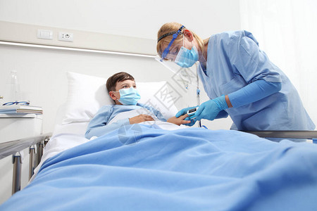 护士在病床上给病人的孩子带脉搏血氧仪背景图片