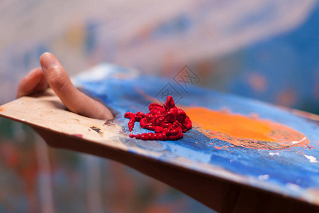 女画家拿着红色油漆的木制调色板图片