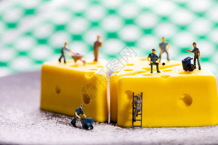 一个小工人模型正在制作芝士蛋糕塑造工人微型公司员图片