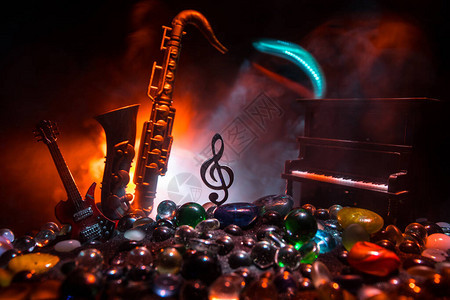 音乐概念音乐符号高音谱号不锈钢微型与雾背景上的彩色调光低光下的乐器图片
