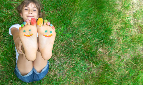 孩子们的脚在绿草上微笑着颜料有选择图片