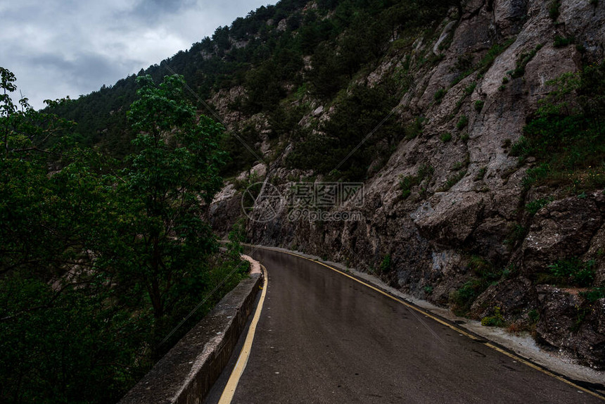 雨季穿过山林的柏油路在雨中的春天森林中的道路完美的柏油图片