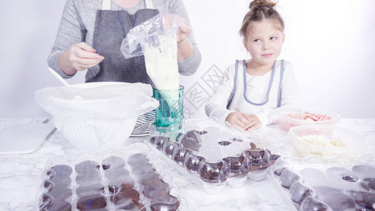巧克力牛奶飞溅一步小女孩帮助用巧克力雪花装饰迷背景