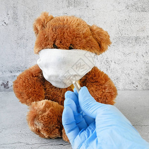 戴着医用外科口罩的棕色泰迪熊图片