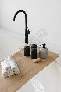 现代浴室黑色水龙头的舒适浴缸上图片