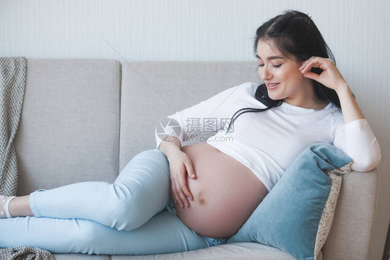 有吸引力的年轻女子怀着孩子怀孕妇女室内女拥图片