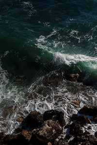 海浪背景打破海水岩石海岸波涛汹涌的大海绿松石水梯度泡沫在公海的大浪夏季风海背景图片