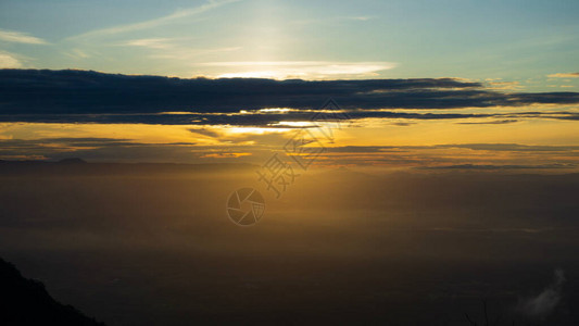 风景的色和山谷地平线上光亮的日出天空在雾山上闪亮图片