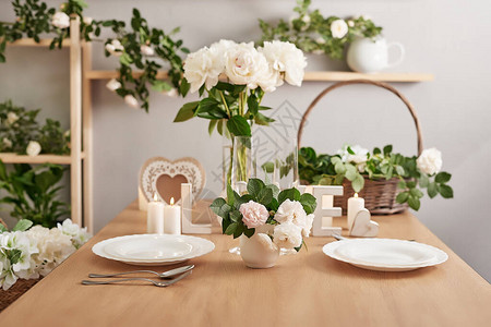 婚礼请柬浪漫的烛光晚餐婚礼餐桌装饰2月14日情人节背景与鲜花玫瑰和牡丹节日餐桌布图片