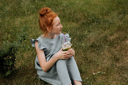 红头发女孩坐在草地上手图片