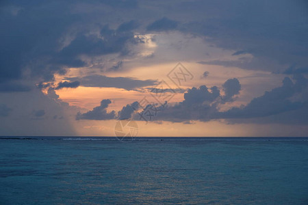 地平线上蓝色和平海浪的蓝色云中日出图片