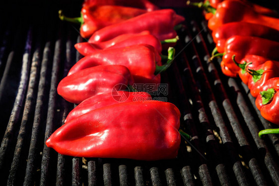 在黑金属烧烤炉街头食品市场上烹煮和展示供销售的新鲜成熟有机红辣椒图片