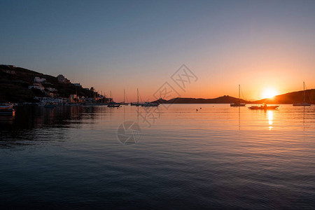 希腊在海水的日落橙色停泊在Vourkari港口的船只图片
