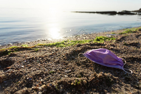 海洋污染废弃的医用口罩躺在户外污染的海滩上具有文本可用空图片
