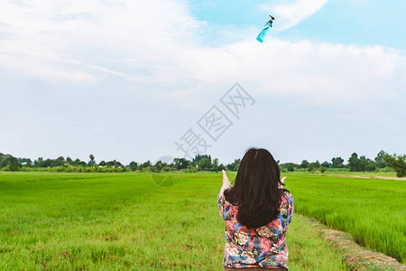 女后视角举起手来等待稻田里从天上掉下酒精凝胶瓶图片