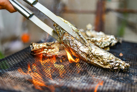 在火上的烤架上用箔纸烤鱼图片