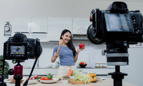 社交媒体概念一个快乐的女人站在里用相机在线录制视频快乐的亚洲女人vlogger直播在线视频教学图片