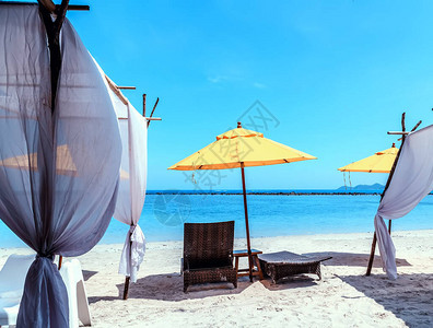 两张空椅子和黄色伞在白色沙滩的加勒比海滩上度假和旅图片