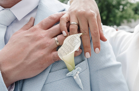 结婚戒指的年轻人的手婚礼当天的详细信息马蹄莲花配偶新婚夫图片