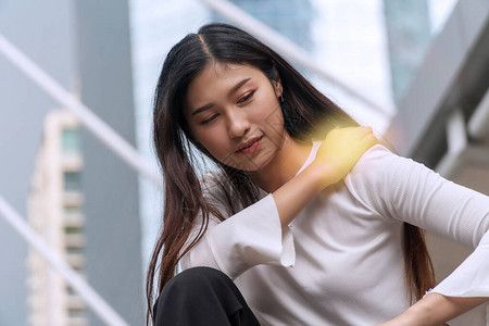 肩部疼痛或僵硬的年轻女子心烦意乱图片