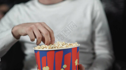男人在电影院吃爆米花看电影照片图片