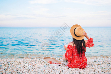 在沙滩上野餐看海的女人的背影图片