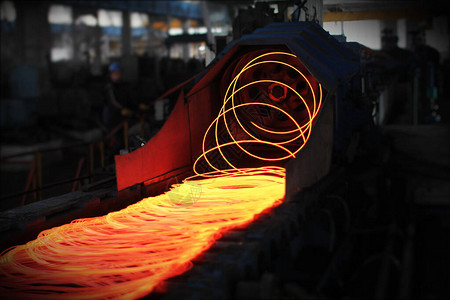 红热钢铁丝棒或熔化钢铸造后的圆圈连续铸造机铁匠和冶金工业的背图片