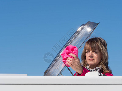 汽车女主人用粉色布清洗其车辆的天窗舱门图片