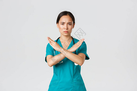 不高兴看起来严肃的亚洲女医生表现出交叉手势图片