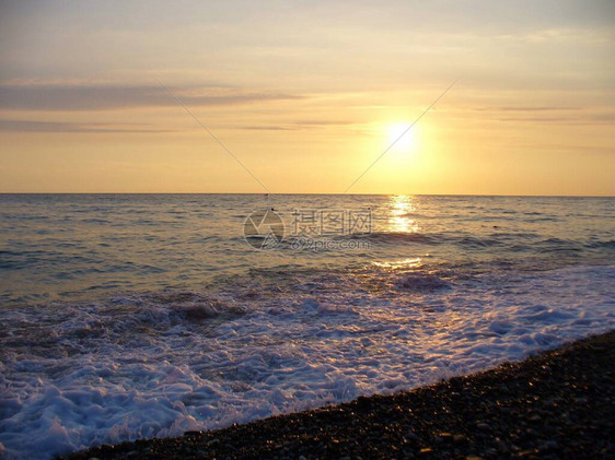 海上冲浪日落时分在海边冲浪海浪的美丽风景在日落的傍晚sunhore的背景下海浪以太阳为背图片