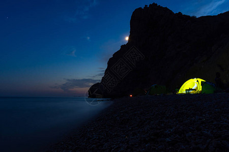 晚上在沙滩上搭帐篷满月在山上户外休闲夜海景带着帐篷旅行在夜海图片