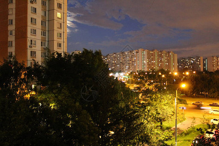 莫斯科市美丽的夜景照片城市景观莫斯科市晚上的街道路上有汽车夏天有绿叶的树高层建筑背景图片