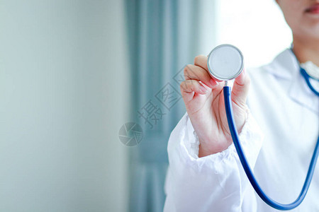 一位女医生拿着听诊器在诊所检查病人图片