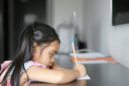 亚洲儿童可爱或小女孩微笑勤奋的写作或绘画图片