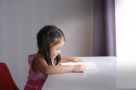 亚洲儿童或小女孩笑得开心或学生喜欢阅读书籍图片