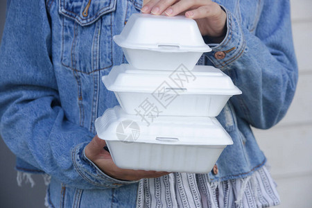 女人手拿着外卖的泡沫午餐盒单用食图片