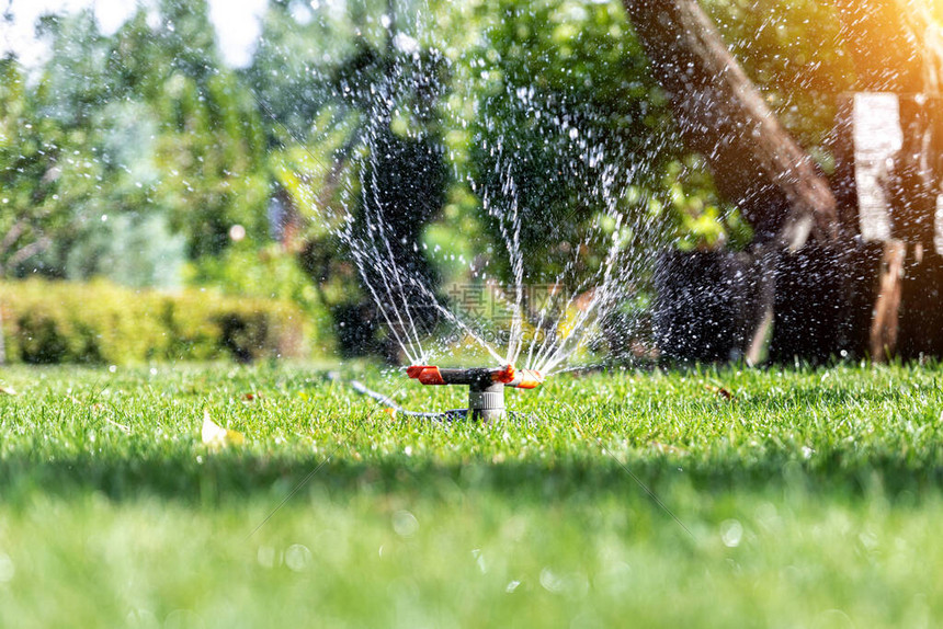 在草坪上安装不同旋转喷头的景观自动花园浇水系统时用智能自动喷雾器灌溉草坪和果图片