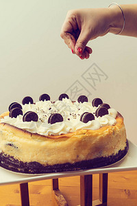 白色背景的奶油蛋糕上黑饼干图片