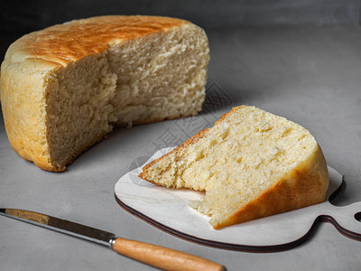 新鲜烘烤自制白面包切成一块在前台厨房图片