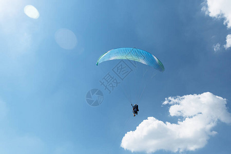 蓝滑翔伞在阳光明媚的白天飞向天空云图片