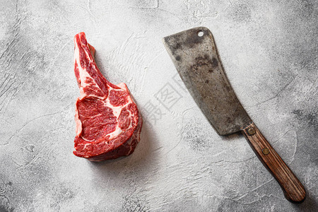 生黑安格斯牛肉战斧牛排在肉美国切肉刀附近的骨头上图片