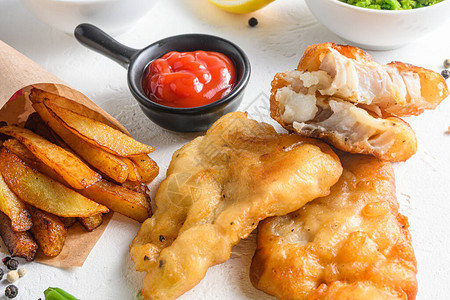 鱼和薯条用蘸酱和柠檬在白色背景的纸锥中涂上酥脆的鳕鱼片细节图片