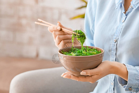 女人吃美味的海藻沙拉特写图片