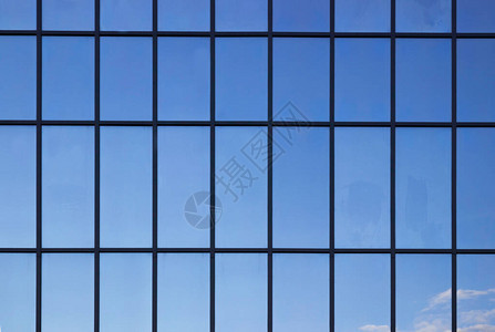 窗户在办公楼里背景上蓝色的天空反射图片