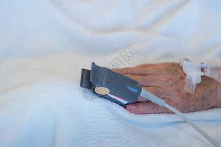 医院室内一位年长病人指尖血氧血氧激素计和心率的近距离检查老年图片