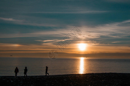 俄罗斯黑海令人印象深刻的美丽冬季日落3人在岸图片