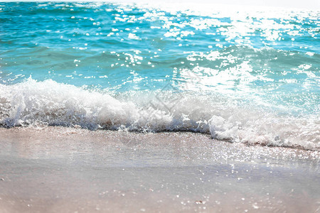 阳光明媚的一天海浪在海滩岸边拍一图片