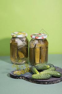 含酸菜和葡萄皮的罐头用草药制成的木切削板上的咸图片