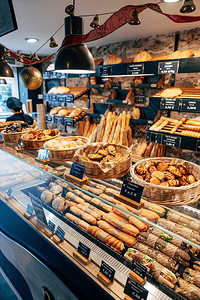 面包店陈列柜有各种面包的编织篮子带面包的架子和带三明治的橱窗背景图片