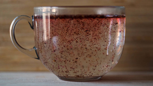 在木墙背景的大玻璃杯中用开水制作芙蓉茶背景图片